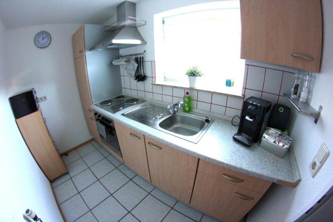 Küche mit Herd, Backofen, Spüle und Kaffeemaschine