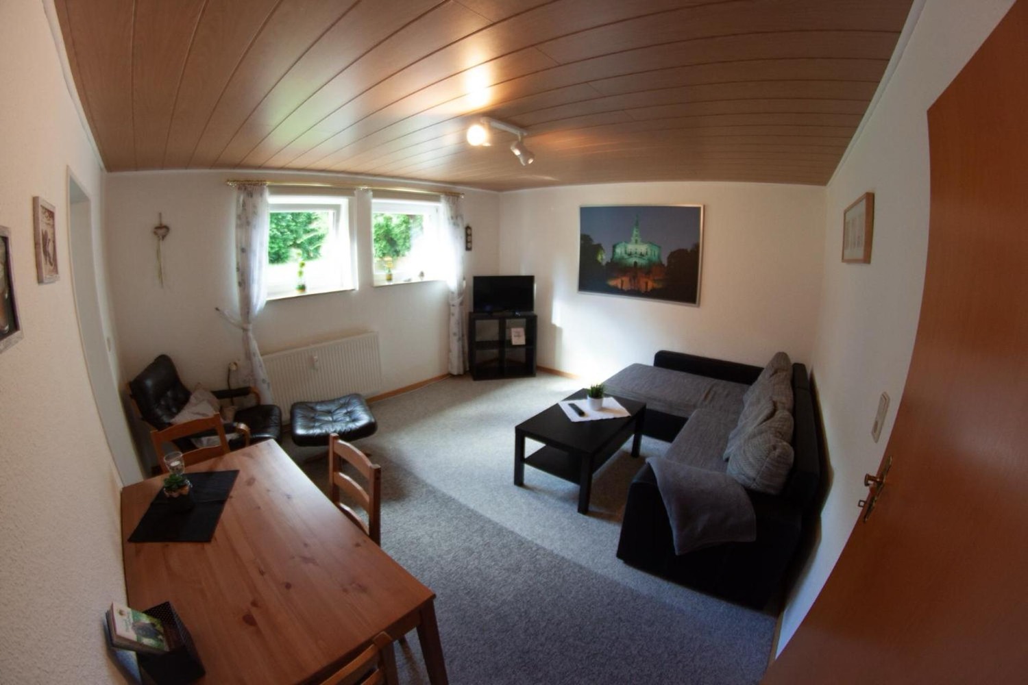 Wohnzimmer mit Eckcouch, Esstisch und Fernseher